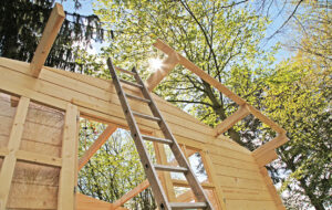 Gartenhaus Aufbau - Leiter lehnt an Holz Gartenhaus im Aufbau
