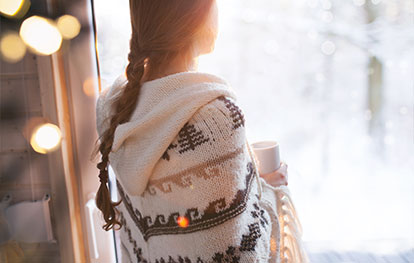 Heizung für Gartenhaus - Person steht an Fenster im Winter