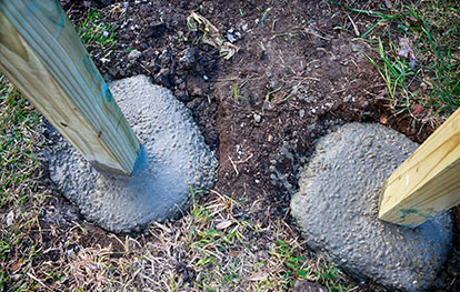 Zaun bauen lassen - Holzpfosten in Betonfundament