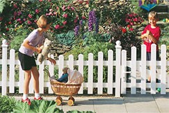 spielende Kinder mit Kinderwagen vor einem weißen Traumgarten Vorgarten Kunststoffzaun