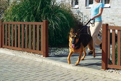 Frau mit Hund im Vorgarten und braunem Wood Plastic Composite Zaun von Traumgarten